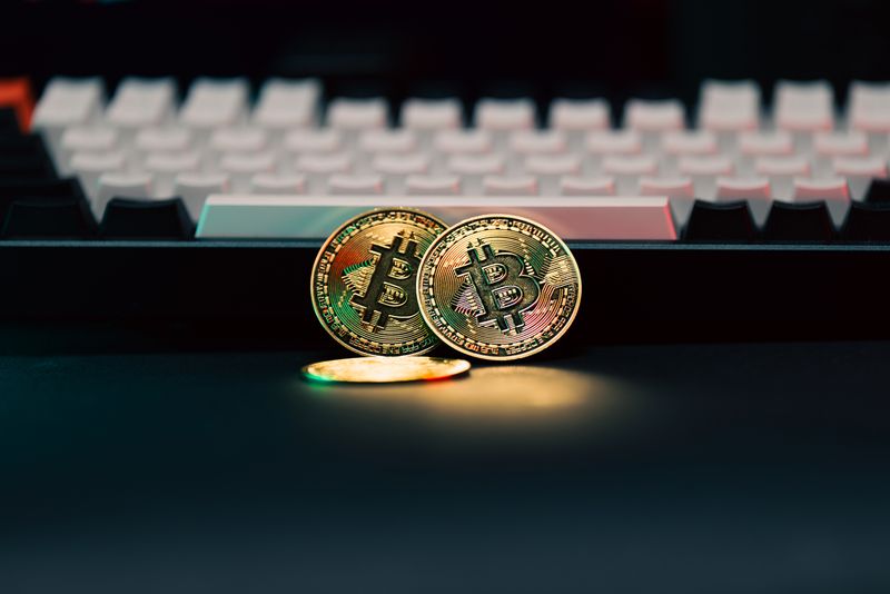 Golden Bitcoin coins in front of a keyboard, symbolizing digital currency and finance