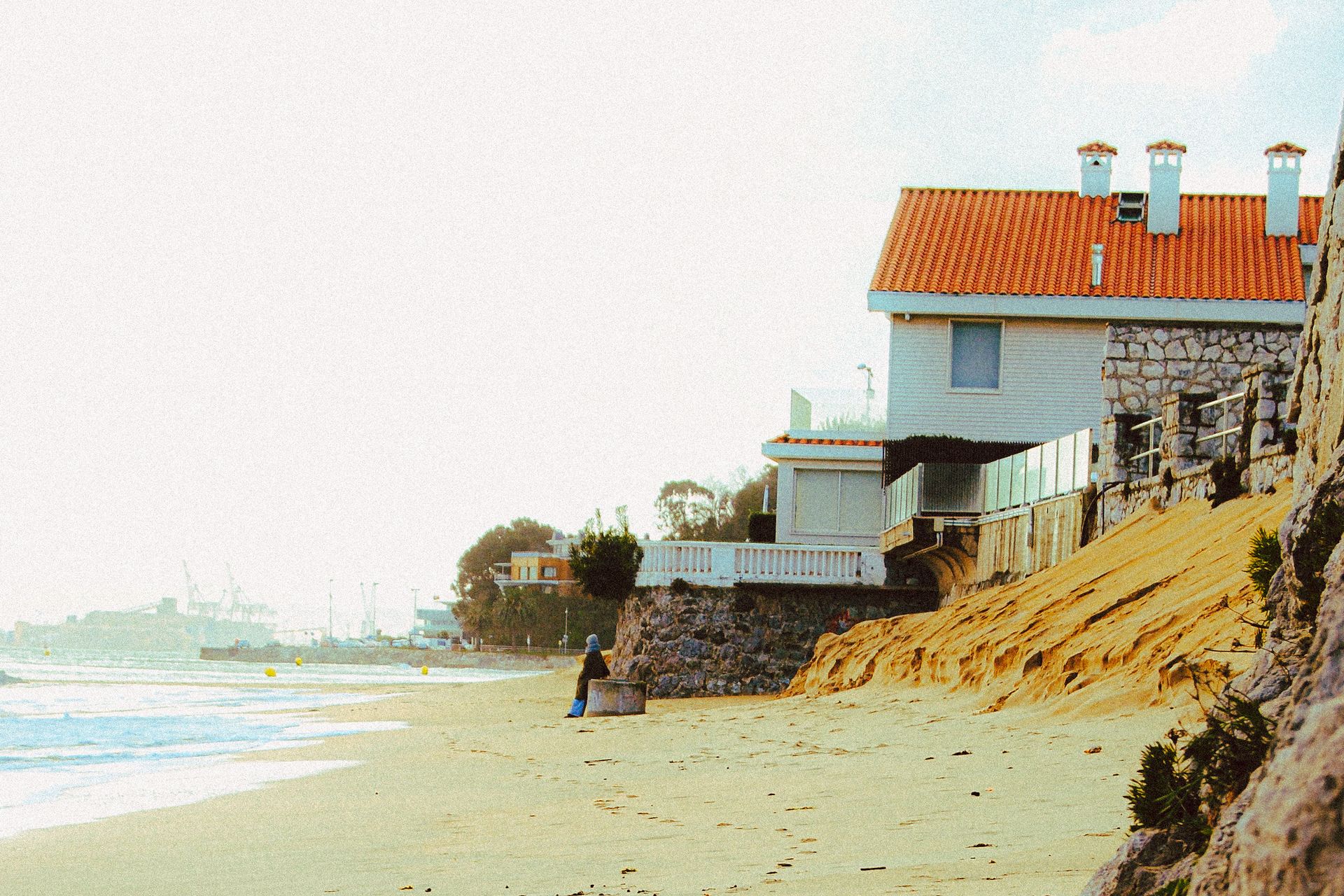 Charming beachfront house with red roof by the ocean, a tranquil retreat for relaxation.