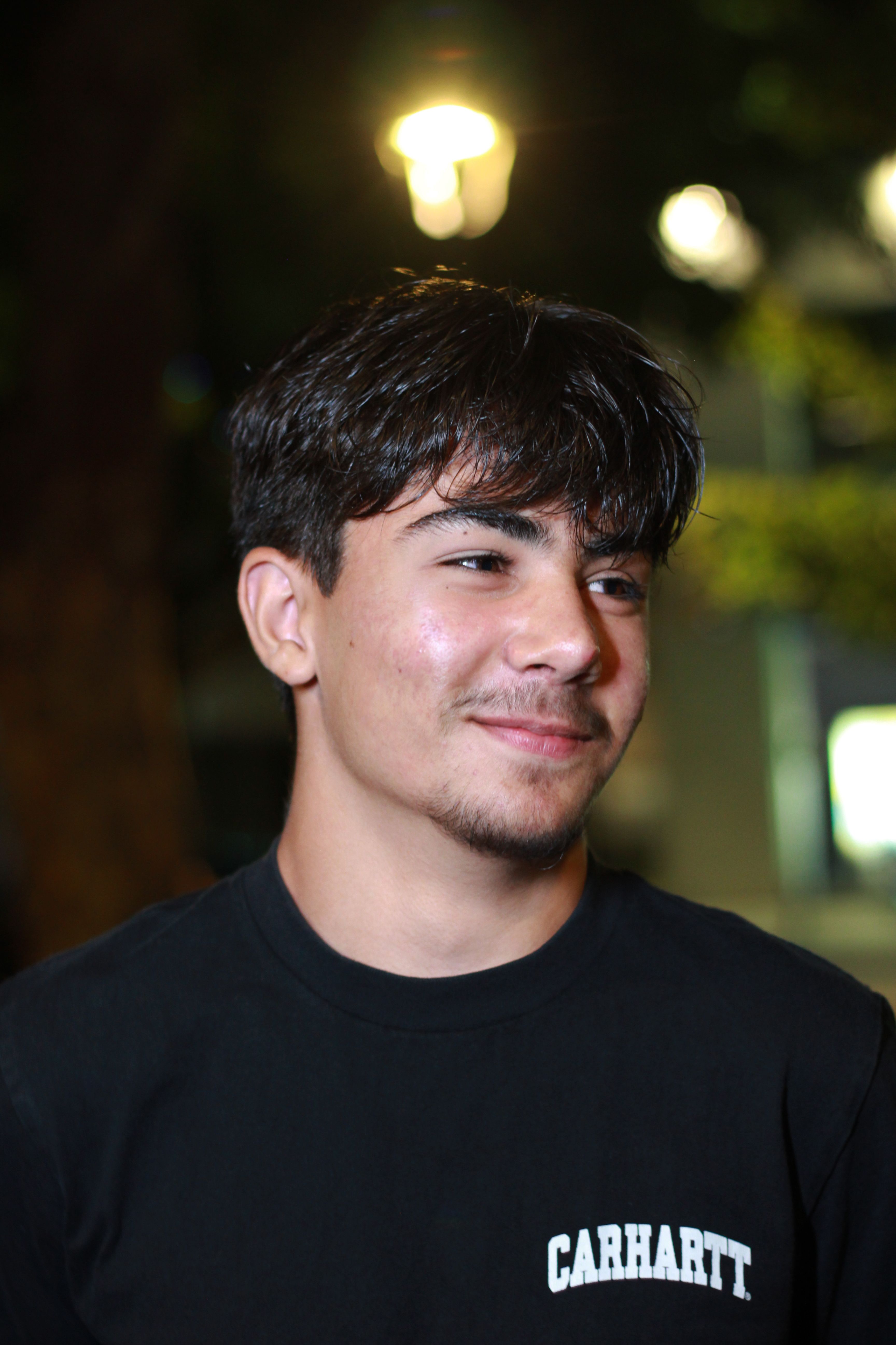 Portrait of a young man smiling casually at night in Póvoa de Lanhoso.