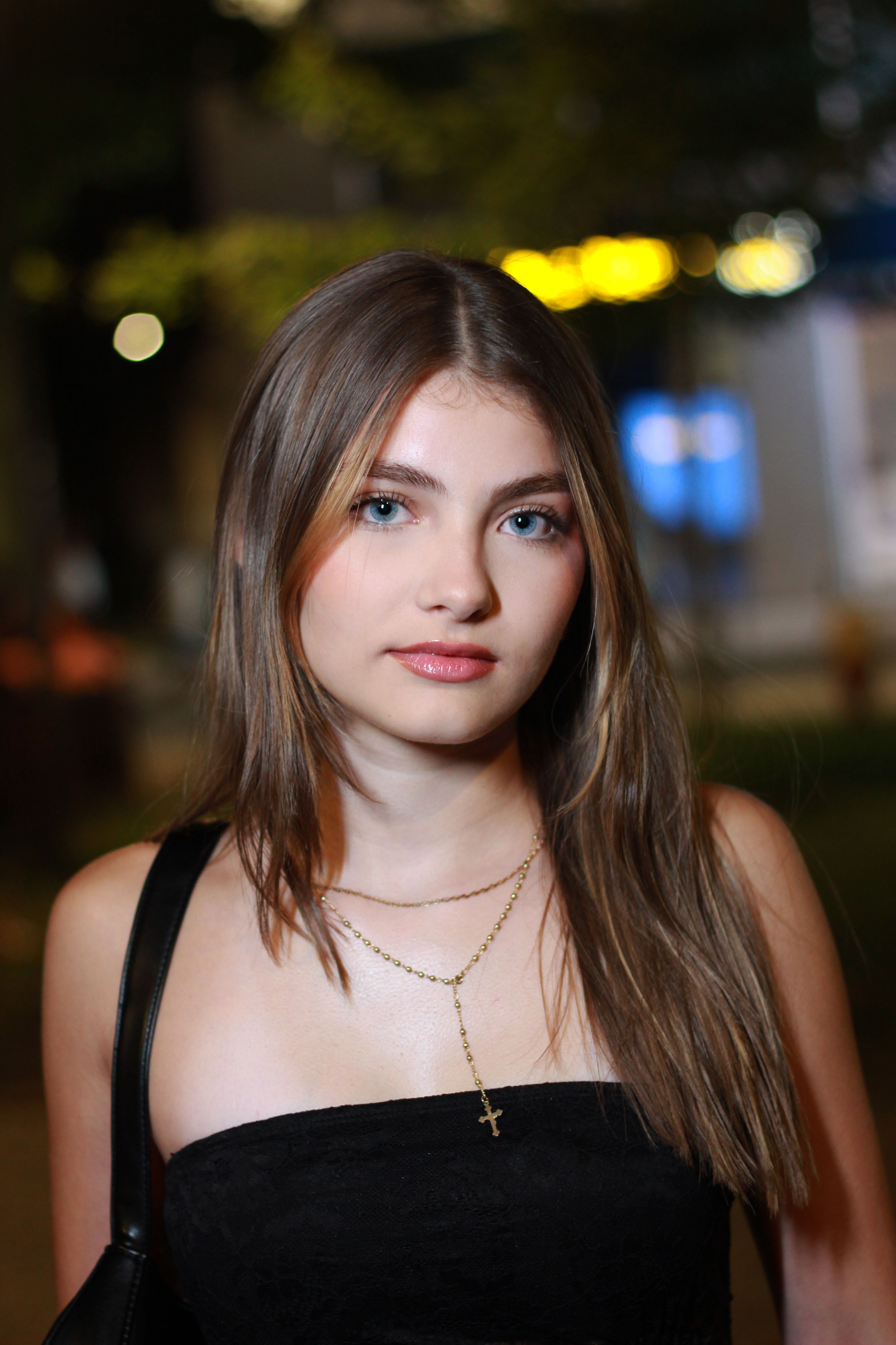 Stylish young woman posing outdoors at night in Póvoa de Lanhoso.