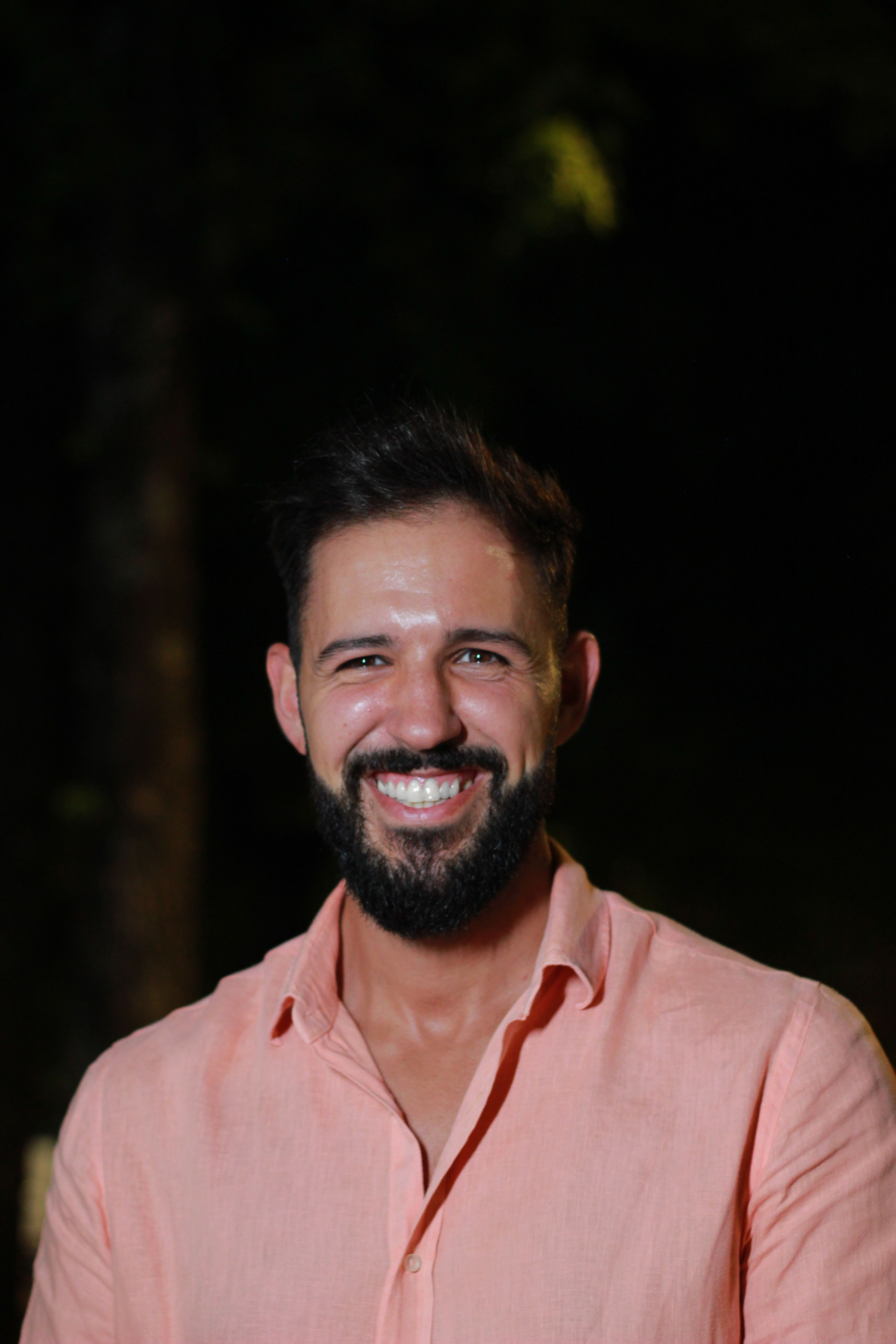 A cheerful man with a beard smiling at night in Póvoa de Lanhoso, Portugal.