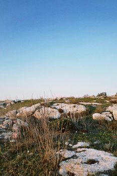 A scenic view of rocky landscape with clear blue sky, capturing nature's serenity.
