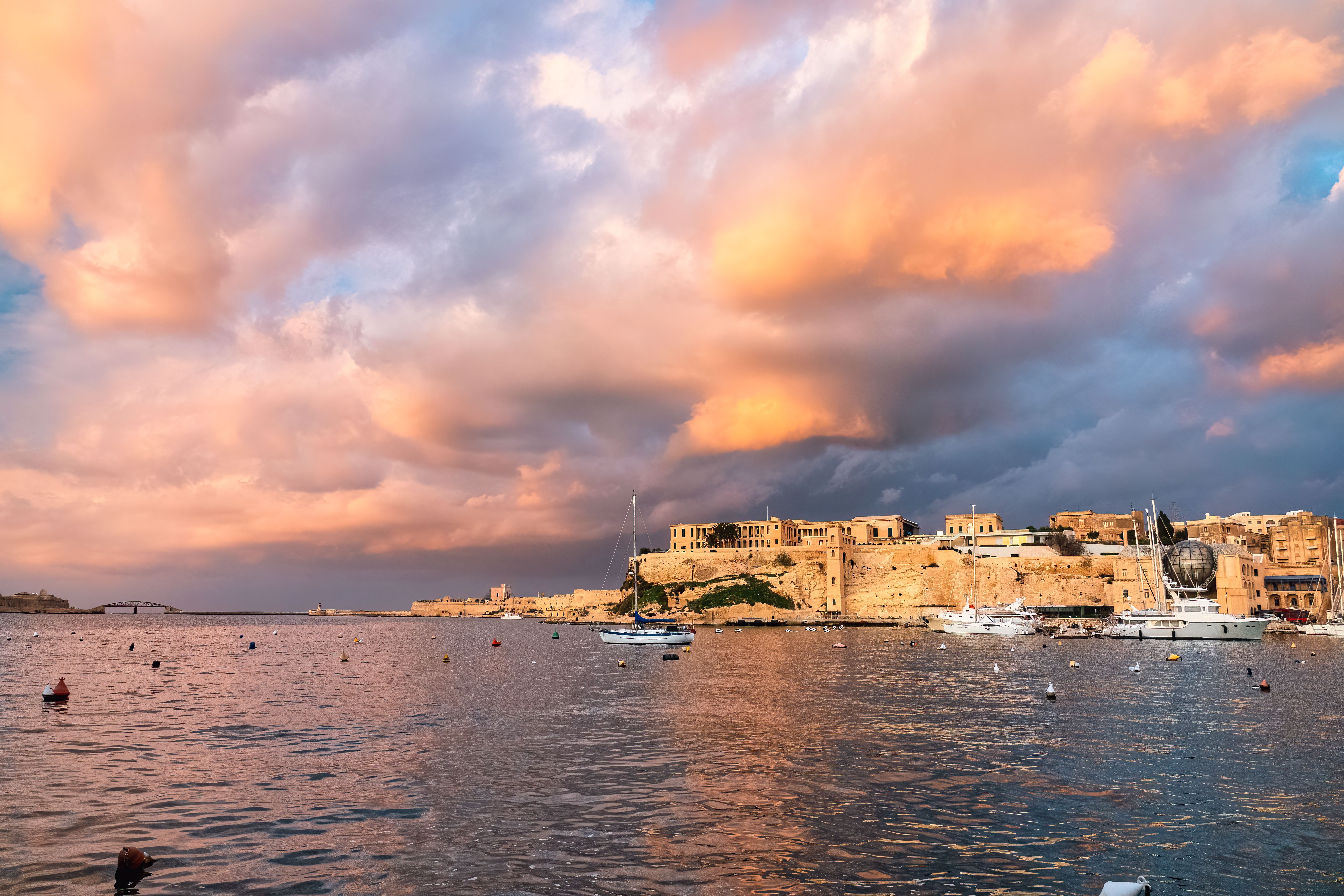 Stunning 2-Day Introduction to Sail Cruising Course in Malta Review: Your Complete Guide to Learning the Ropes Review 2026 - A stunning sunset over the historic waterfront of Valletta, Malta with dramatic clouds and calm waters.
