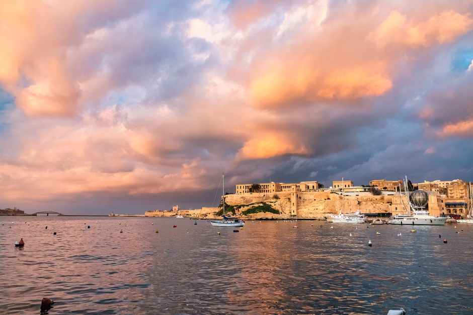 Stunning 2-Day Introduction to Sail Cruising Course in Malta Review: Your Complete Guide to Learning the Ropes Review 2026 - A stunning sunset over the historic waterfront of Valletta, Malta with dramatic clouds and calm waters.