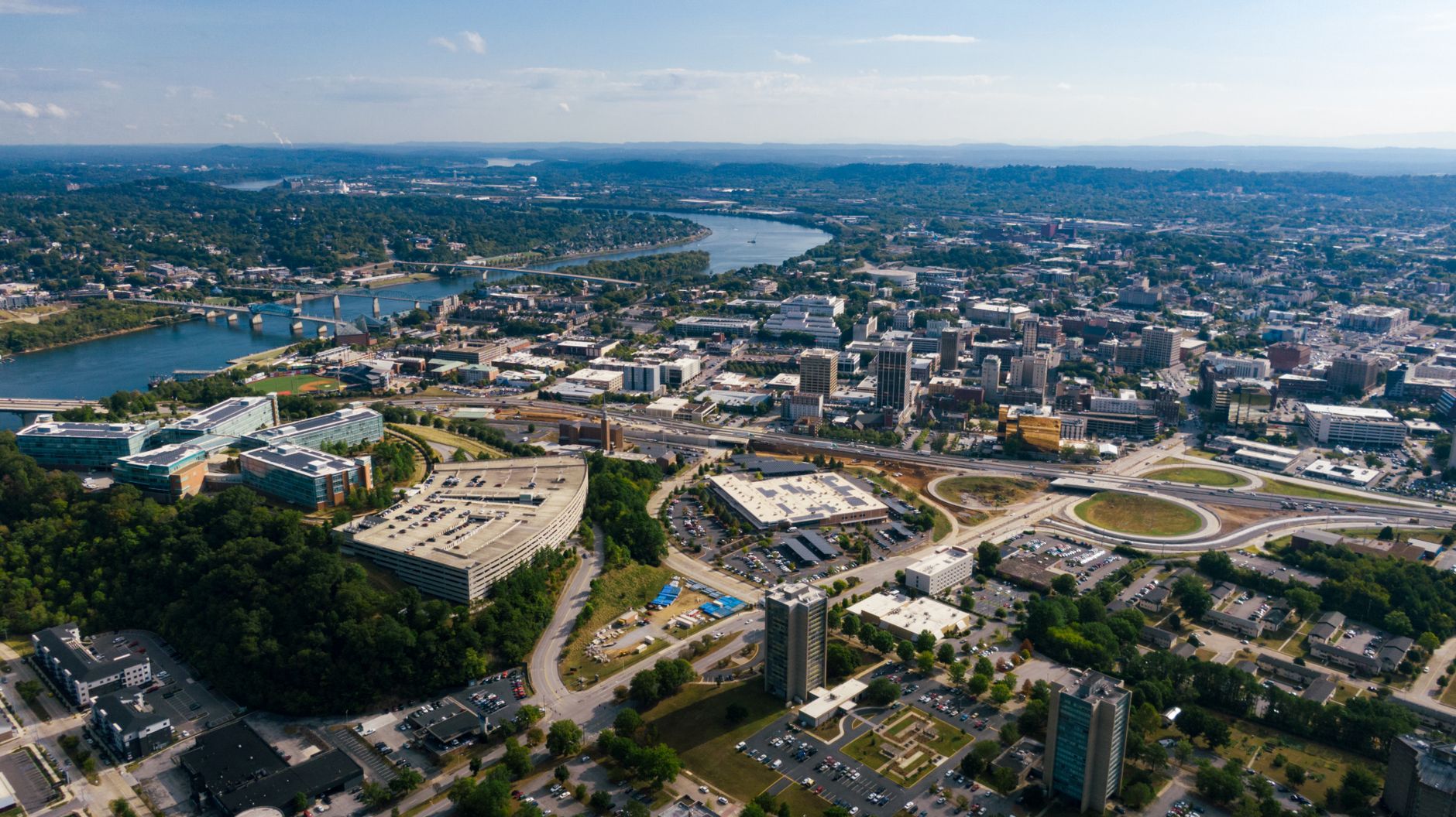 A stunning aerial shot of a cityscape featuring buildings, roads, and a winding river.