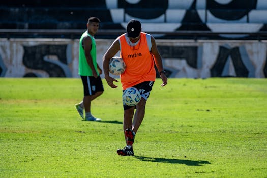 Soccer players practicing skills on a sunny outdoor field.