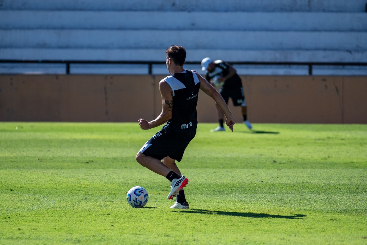 Un futbolista entrenando en solitario sobre el césped de un campo