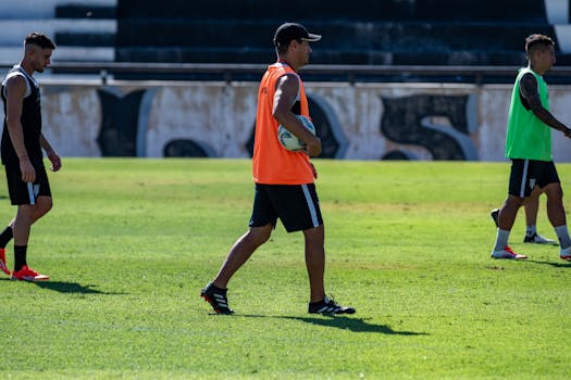 Soccer players training on a grassy field during a sunny day, focusing on teamwork.