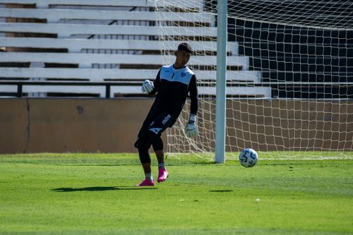 Free Goalkeeper kicks soccer ball on a sunny day during practice match. Stock Photo