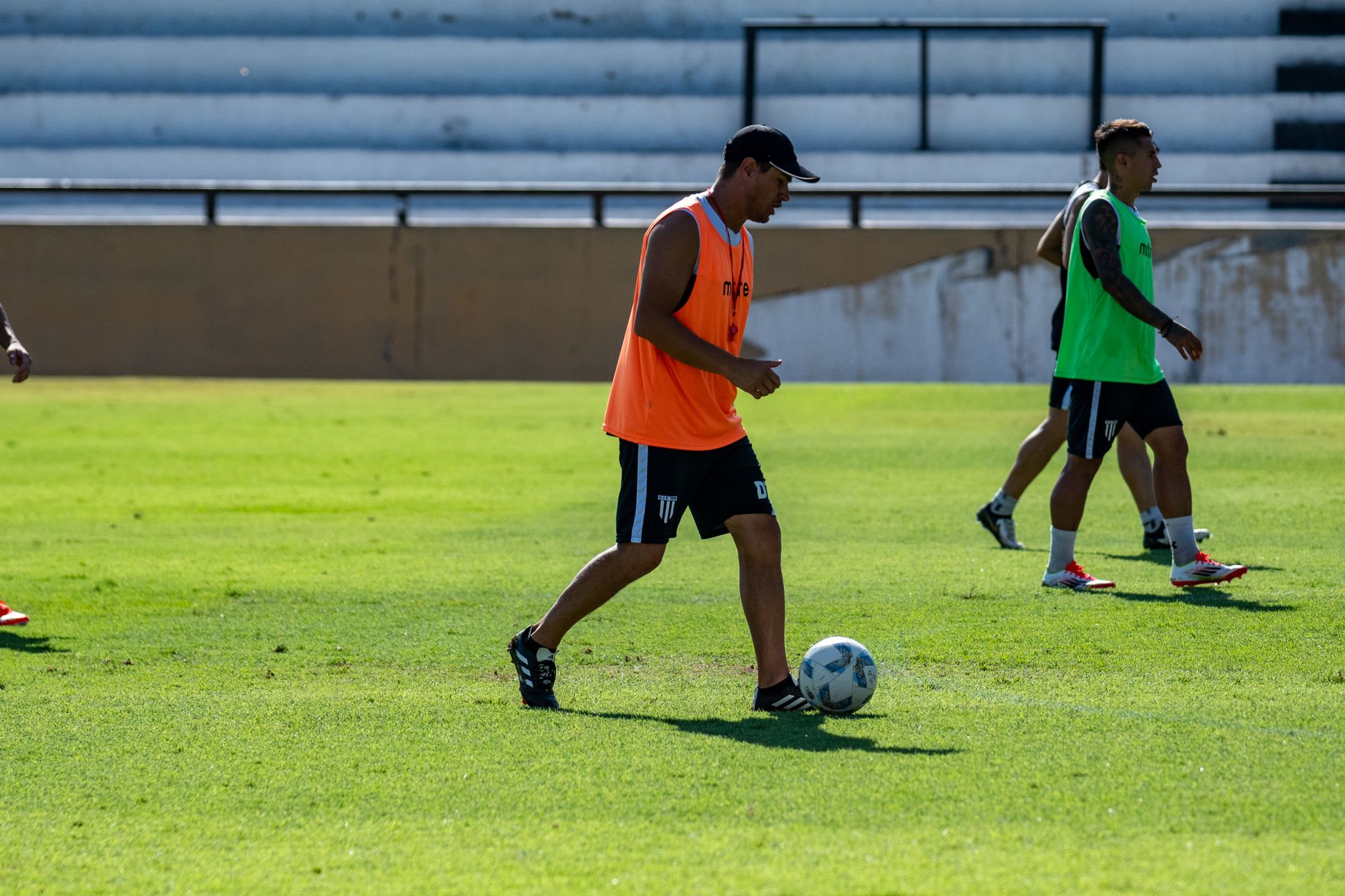 Athletes practice soccer on a sunny day, showcasing teamwork and skills.