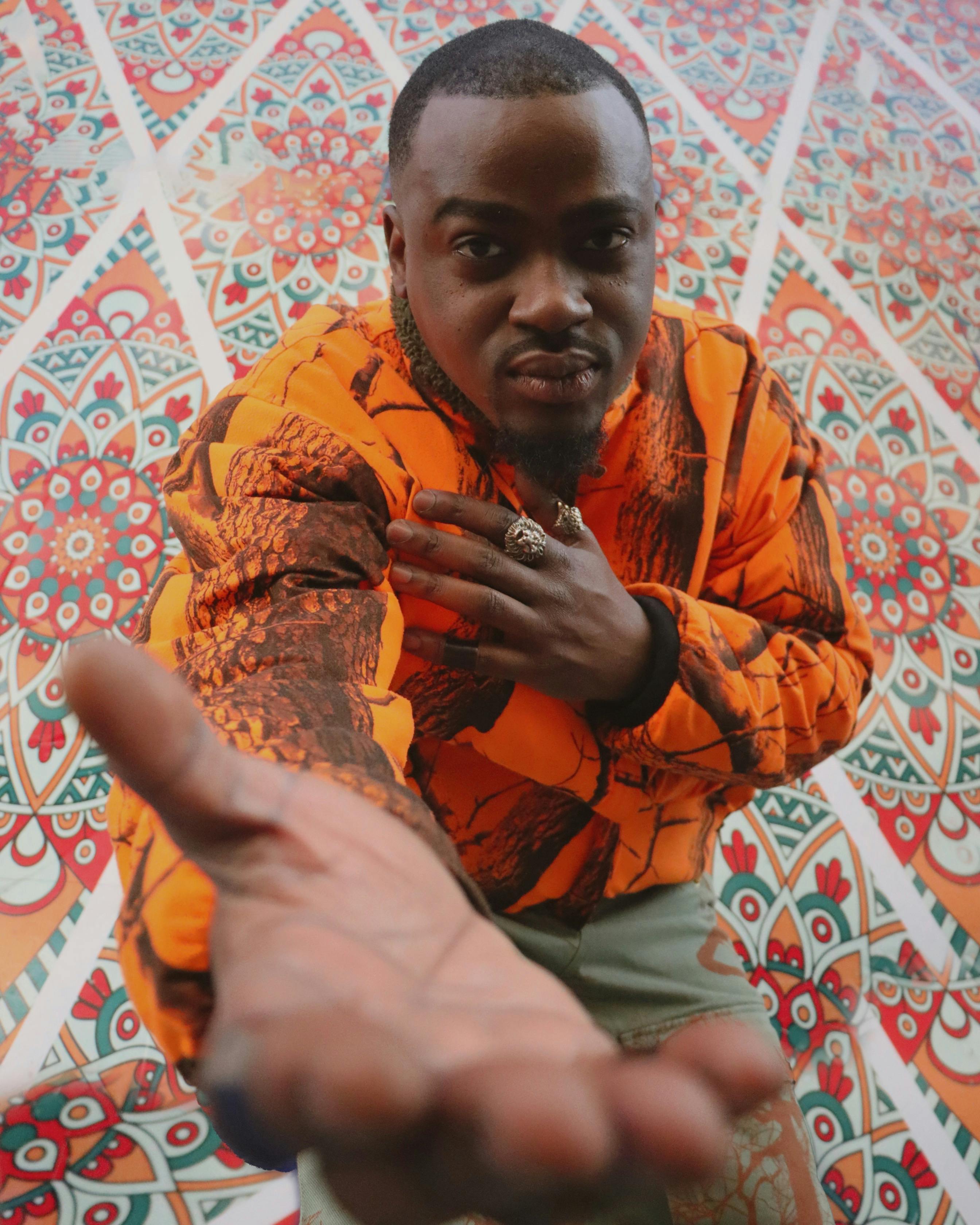 A vibrant portrait capturing African fashion against an intricate Moroccan tile background.
