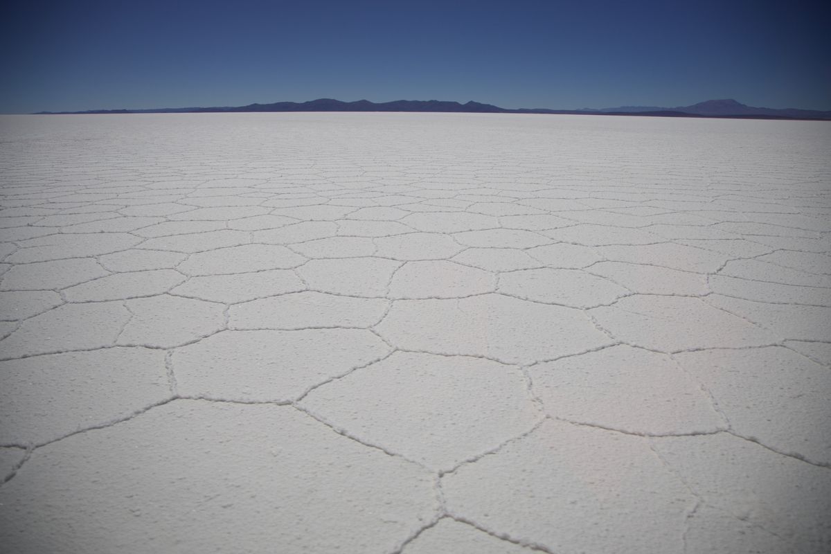 Vast white salt crust of the Salar de Uyuni under blue sky