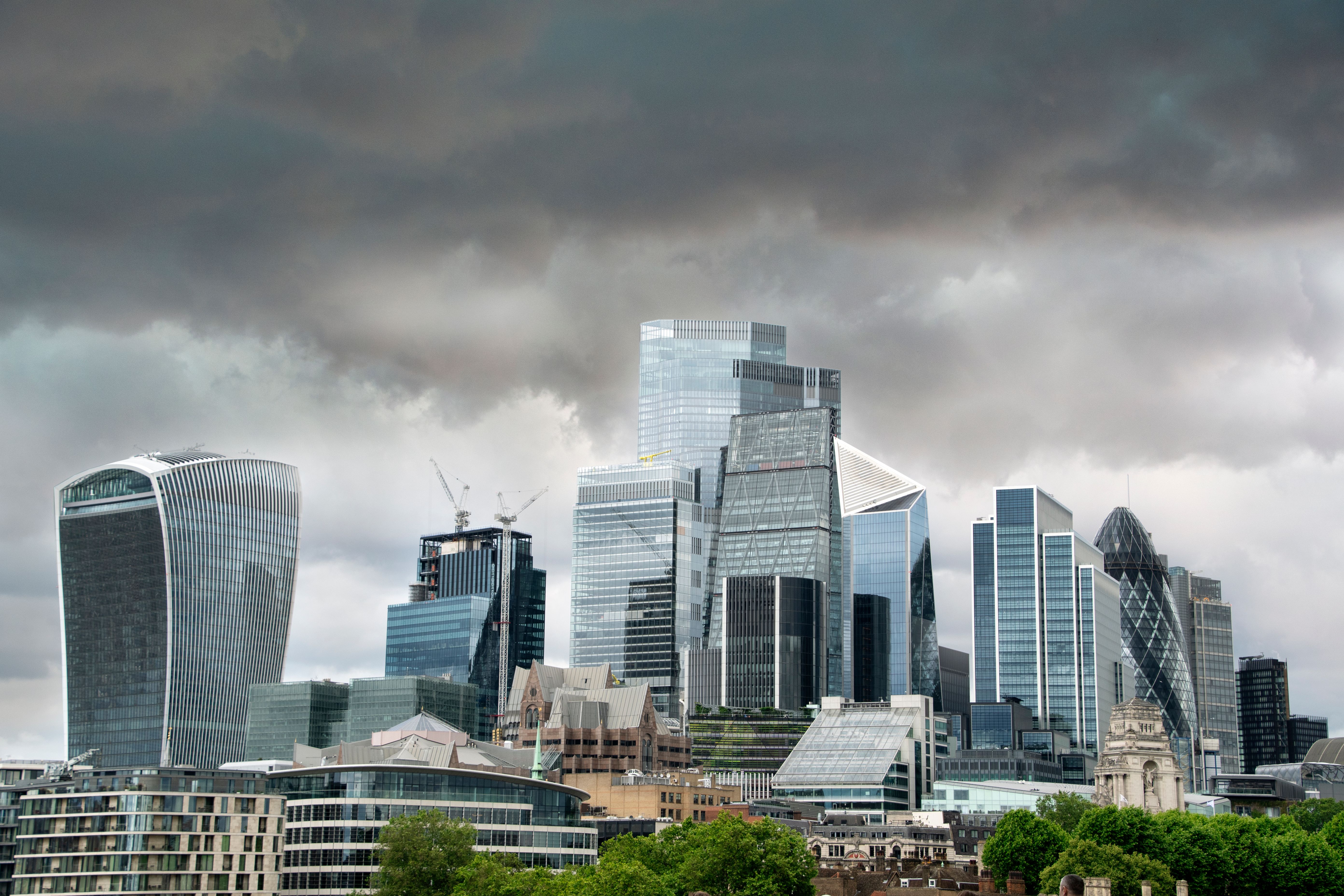 A view of London's skyscrapers under dramatic cloudy skies, showcasing modern architecture.