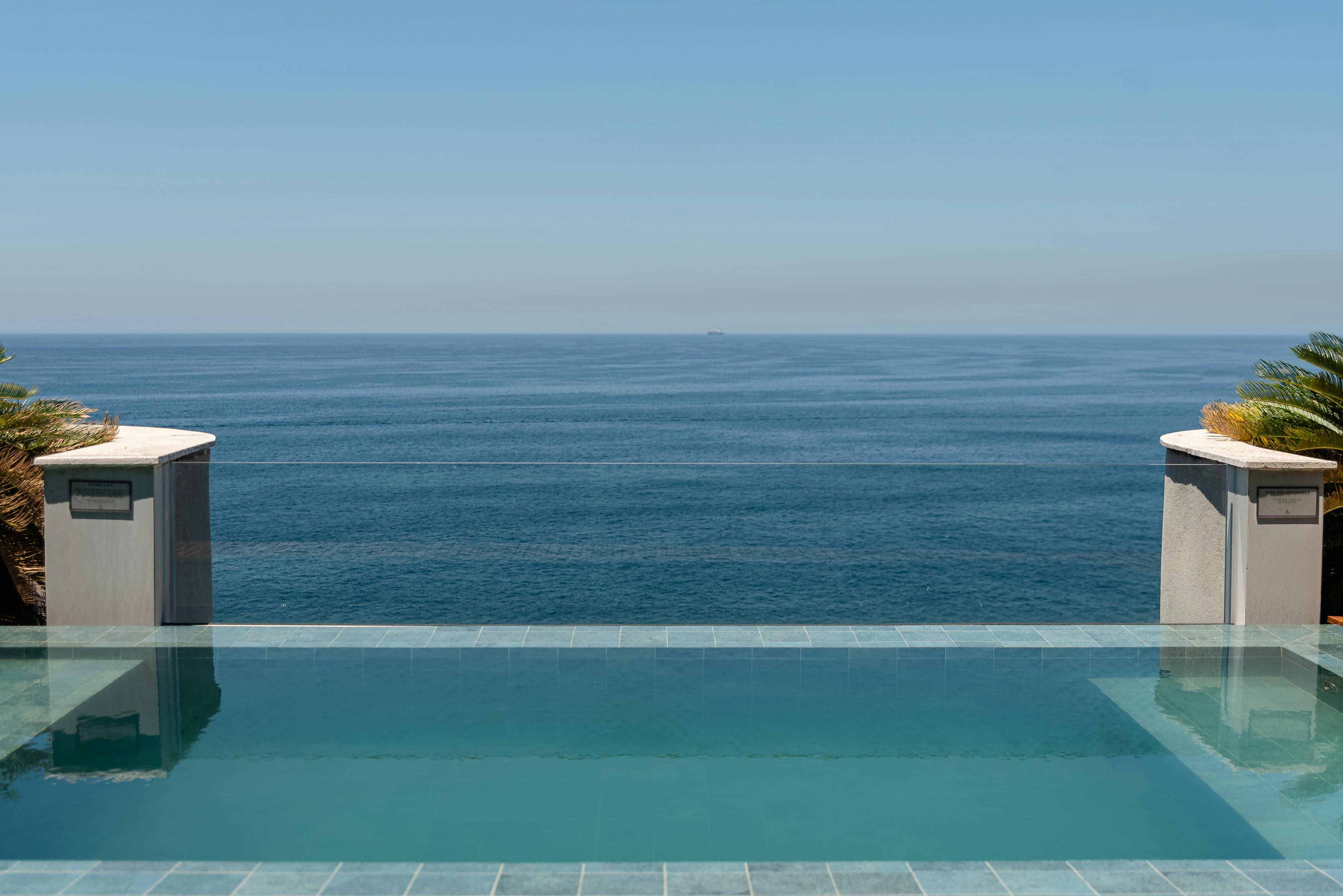 Elegant infinity pool with ocean view, ideal for relaxation and tropical vacations.