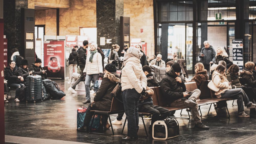 Interiorul aglomerat al gării centrale din Milano, cu călători și bagaje