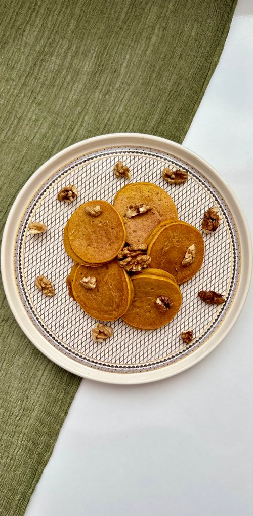 Free Top view of pumpkin pancakes with walnuts on a plate, perfect for autumn mornings. Stock Photo