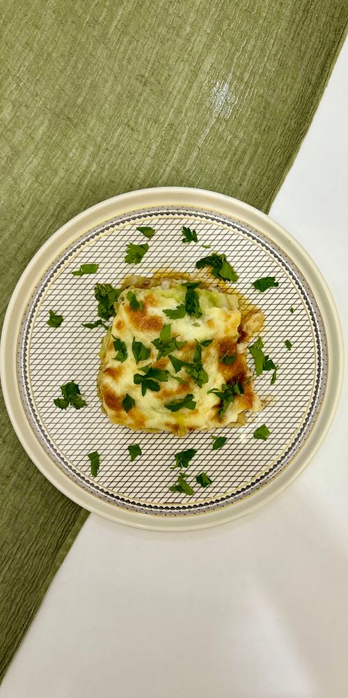 Free Close-up of baked lasagna topped with fresh herbs on a stylish plate. Stock Photo