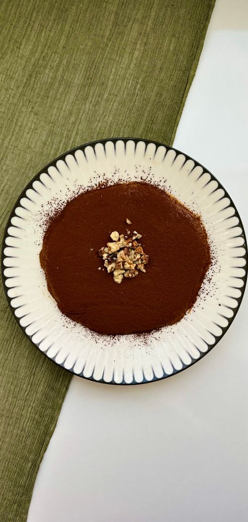 Free Close-up of a dessert with cocoa dust and chopped nuts on a decorative plate. Stock Photo