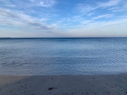 Free A tranquil view of a sandy beach with gentle waves under a clear blue sky in Spain. Stock Photo