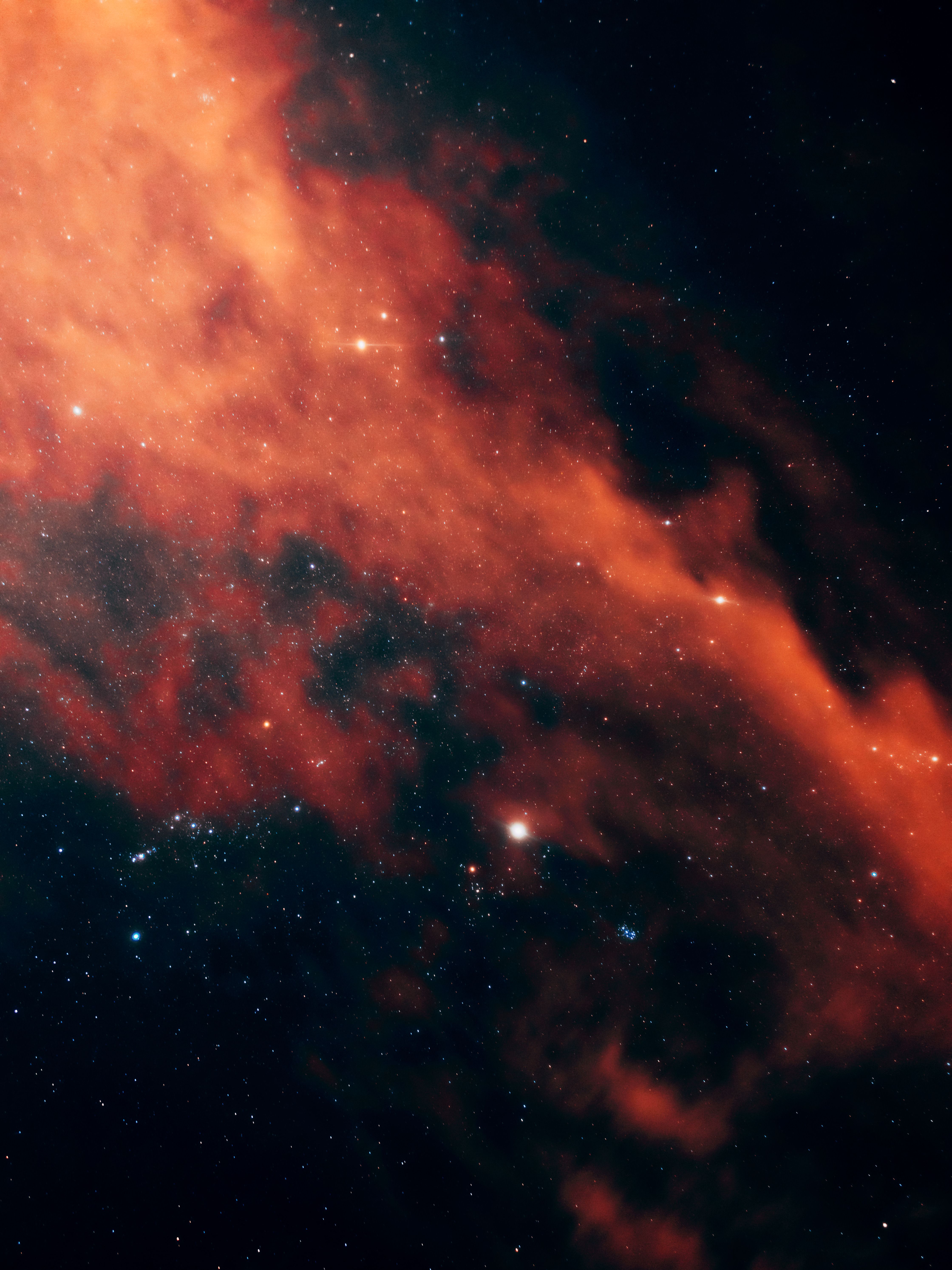 Vivid image of a red nebula with stars in the night sky creating a dramatic cosmic scene.