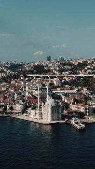 Stunning aerial view of Istanbul's Ortaköy Mosque by the Bosphorus with cityscape backdrop.