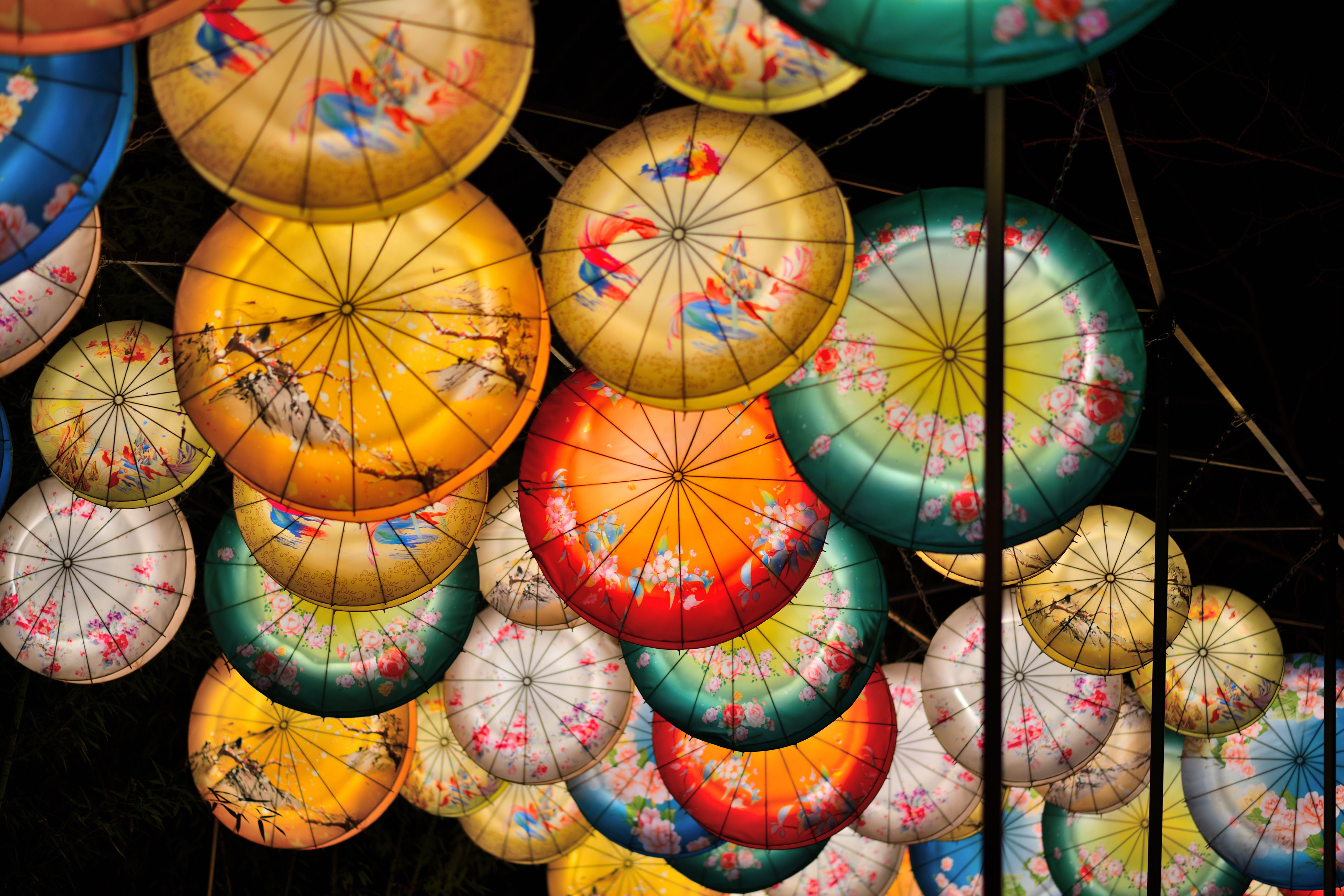 Free Colorful lanterns with intricate designs illuminate the night in a festive atmosphere. Stock Photo