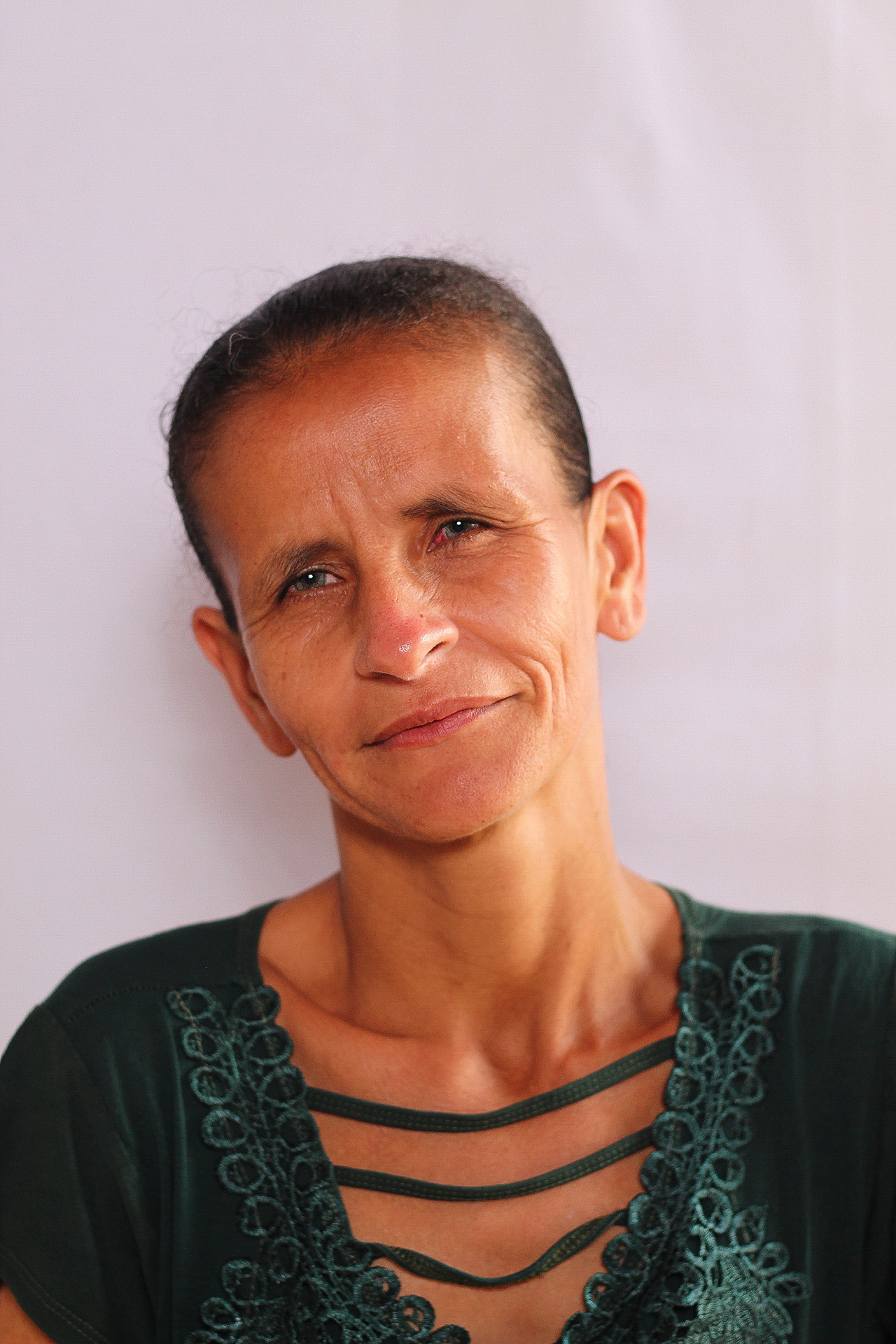 Close-up portrait of a woman with a serene expression and green attire.