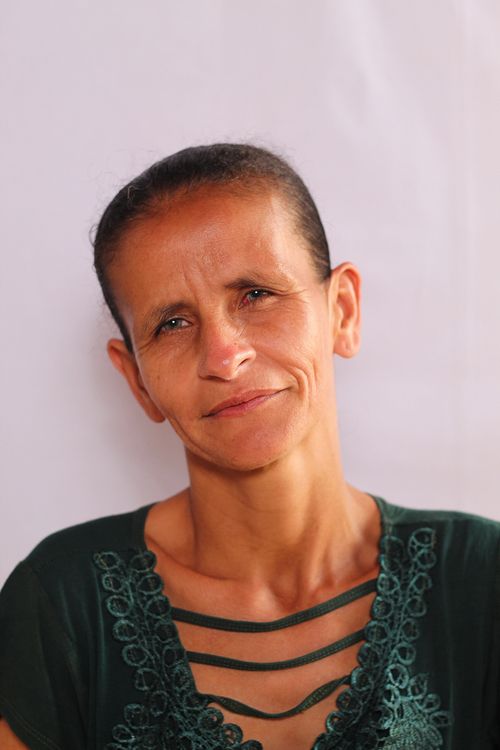 Free Close-up portrait of a woman with a serene expression and green attire. Stock Photo