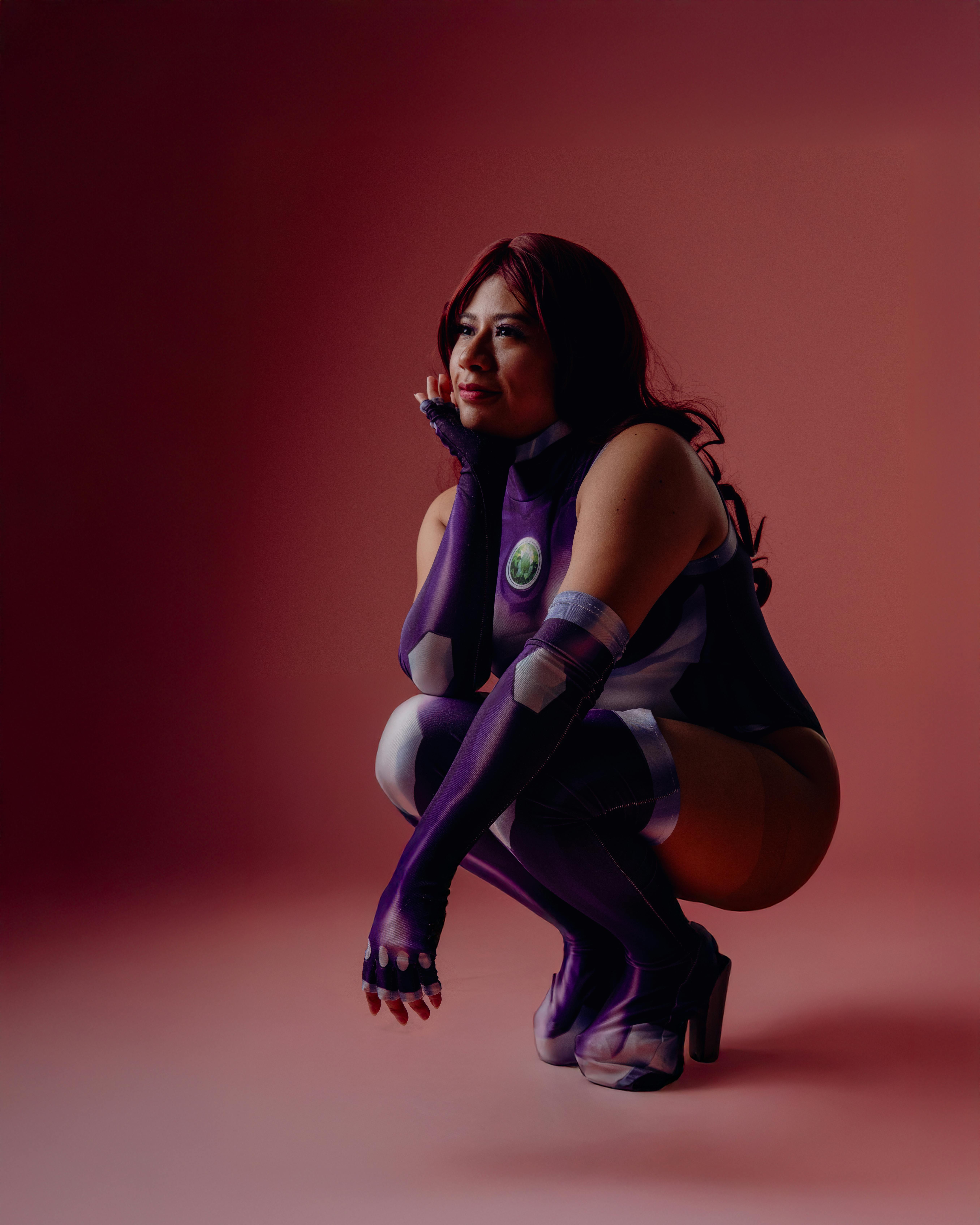 ingyenes Lenyűgöző cosplay portré egy fiatal nővel, lila kosztümben, rózsaszín háttér előtt. Stockfotó