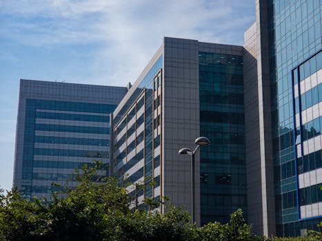 Stylish modern office buildings with glass facades against a clear blue sky, exemplifying urban architecture.