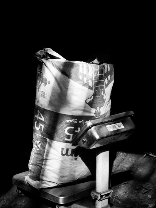 Free Artistic black and white image of a bag on a vintage weighing scale. Stock Photo