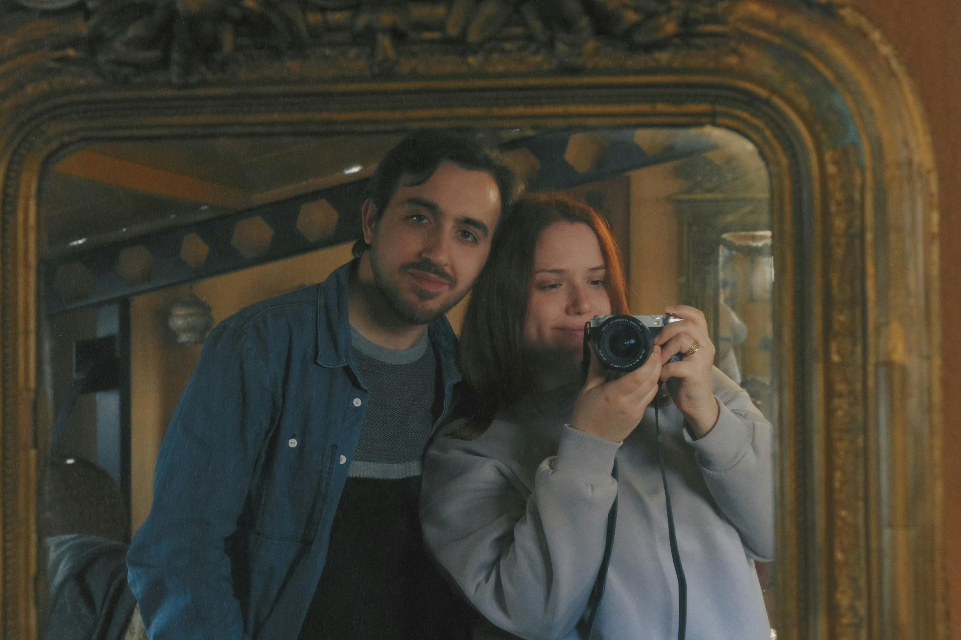 couple taking mirror selfie indoors