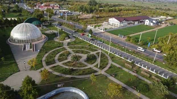 Aerial view of a landscaped park with pathways and a glass dome in Tecuci, Romania.