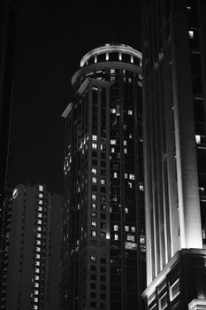 Black and white image of Doha skyscrapers at night, showcasing modern architecture.