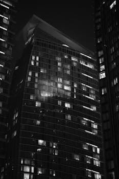 Black and white photo of modern skyscrapers in Doha, Qatar at night, showcasing architectural elegance.