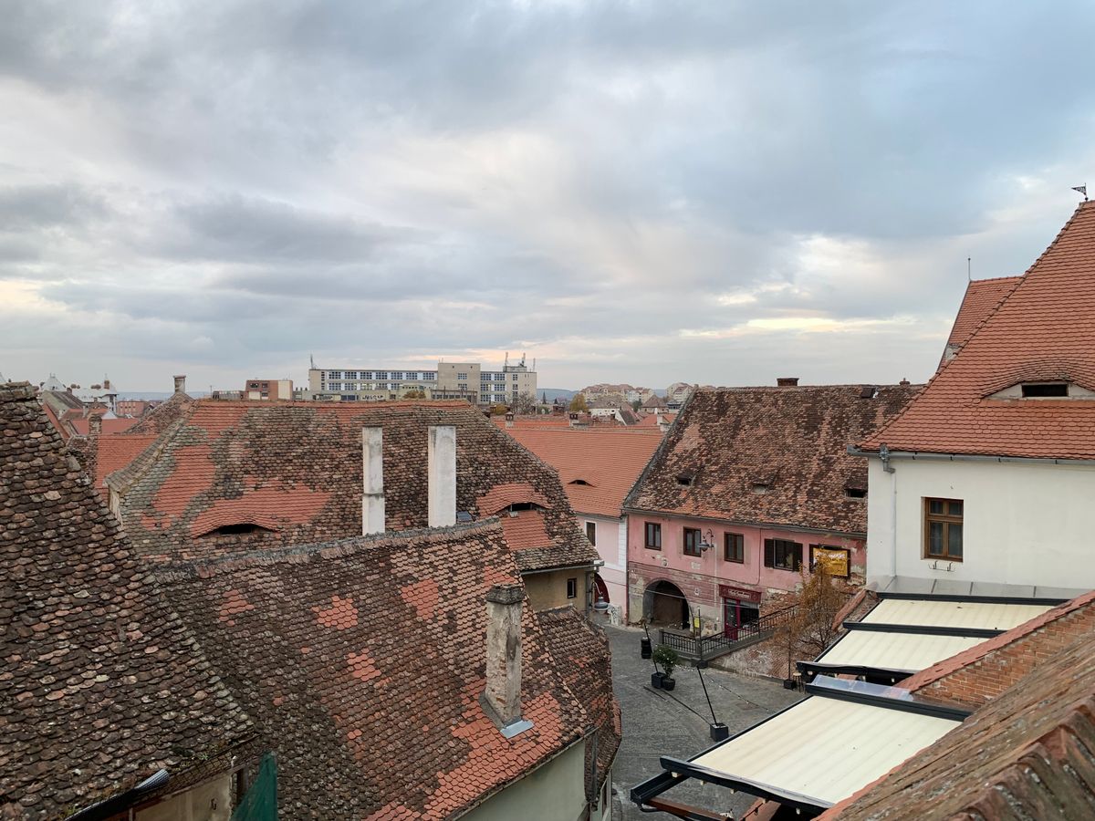 Acoperișurile vechi din Sibiu văzute de sus, sub un cer liniștit