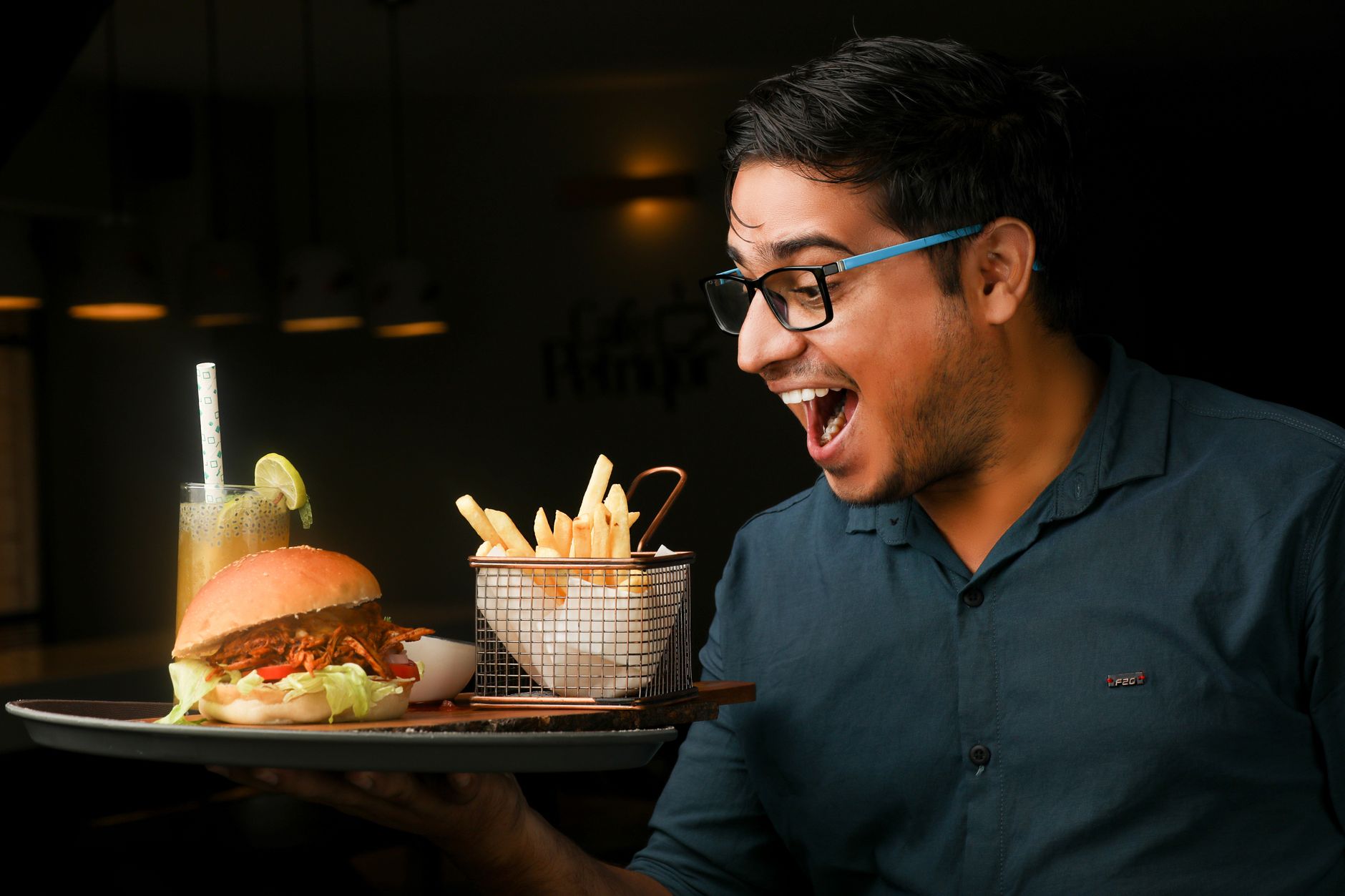 A juicy burger with melted cheese and fresh toppings on a wooden board