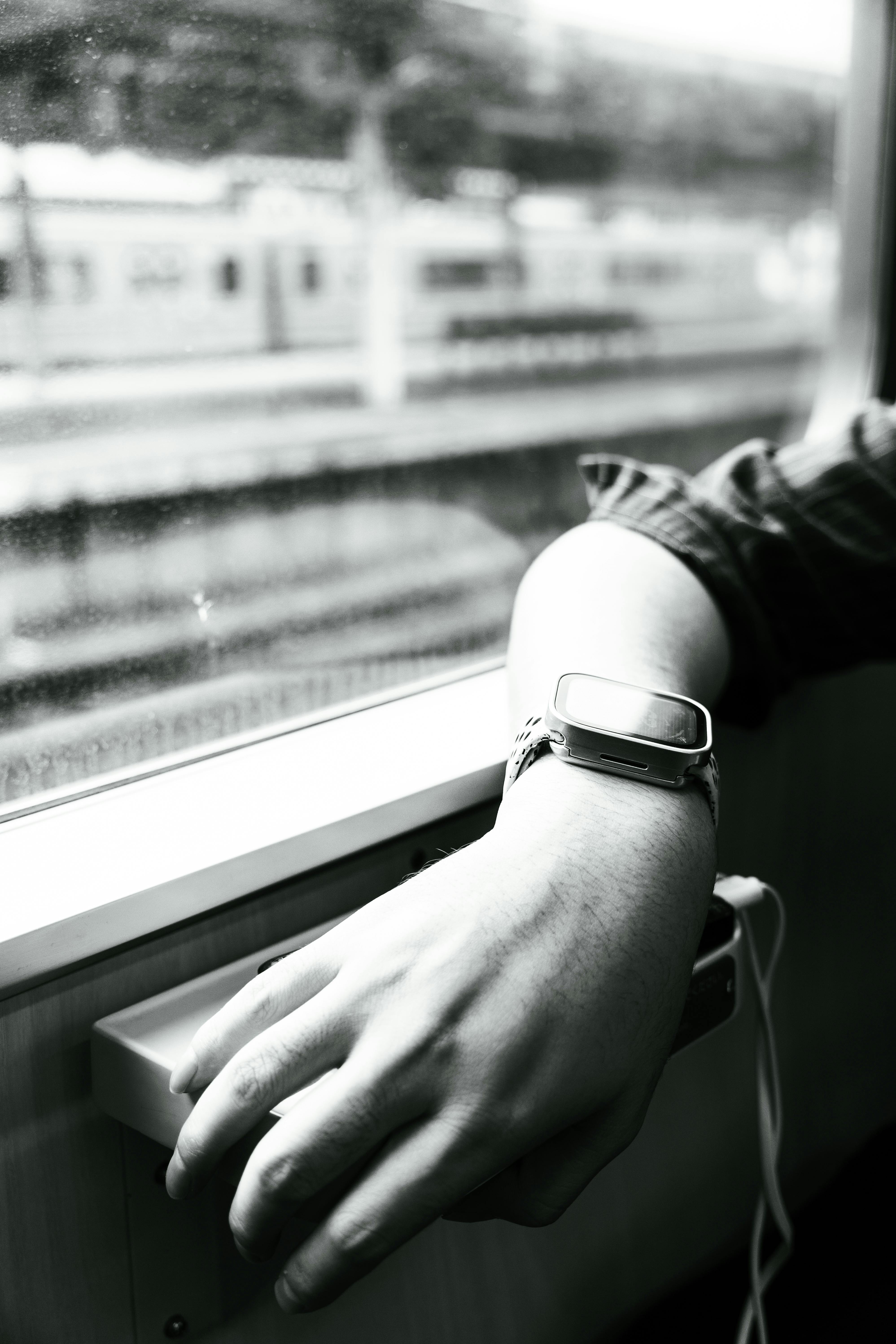 Gratuit Mâna unei persoane care se odihnește lângă fereastra unui tren cu un ceas inteligent, captând starea de spirit de călătorie. Fotografie de stoc