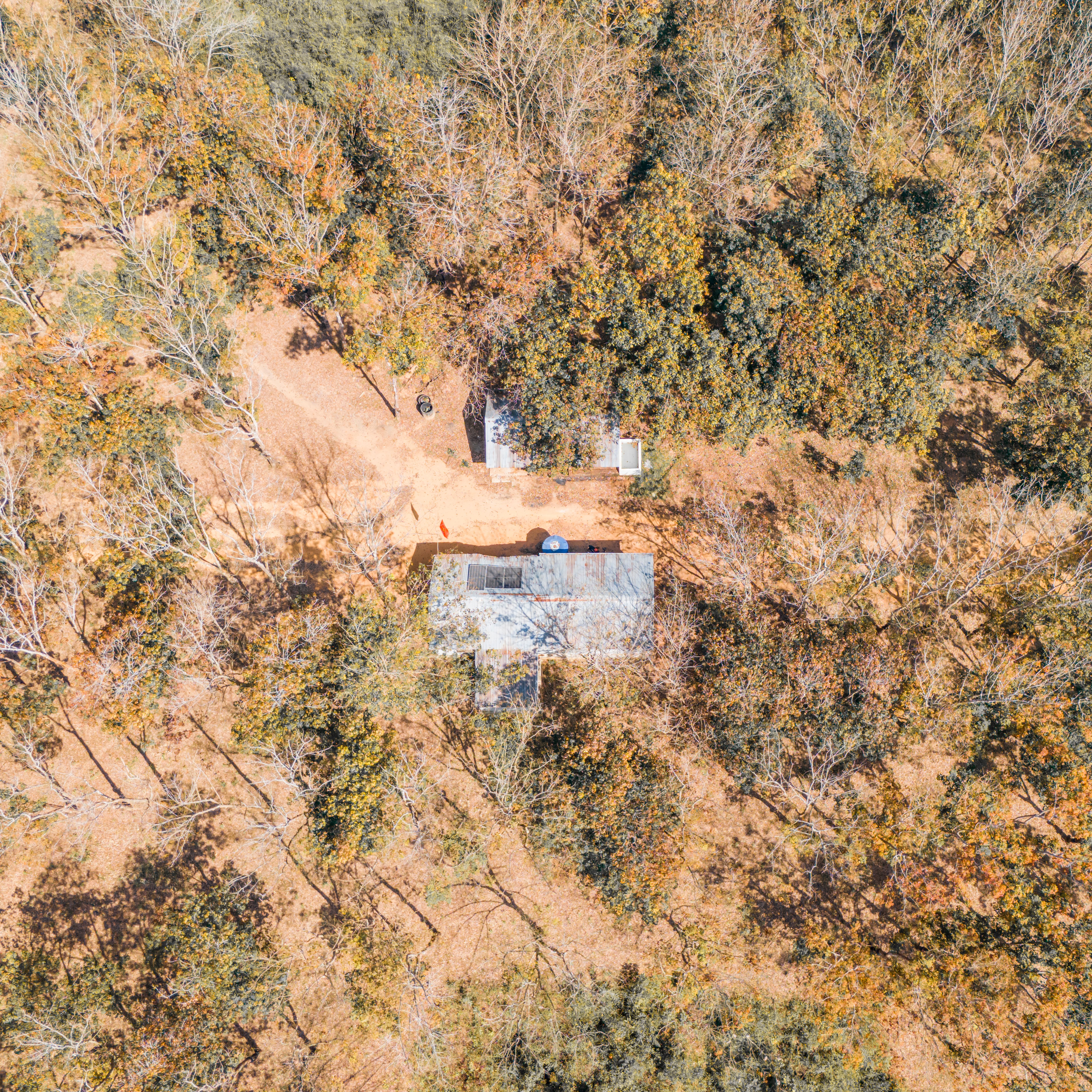 Aerial shot of a forested area and house in Kon Tum, Vietnam during autumn.