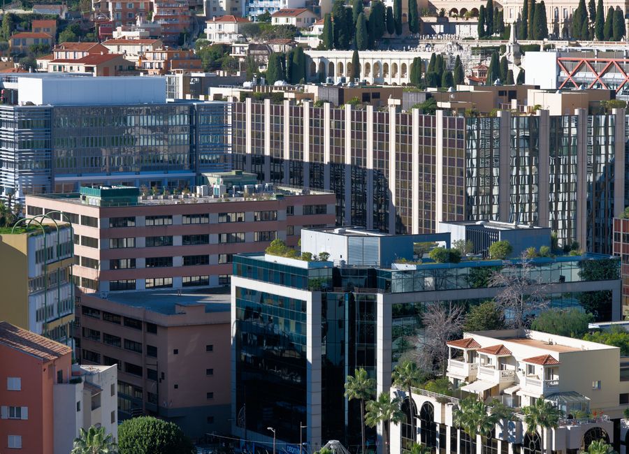 Aerial view showcasing Monaco's modern architectural skyline with skyscrapers and lush greenery.