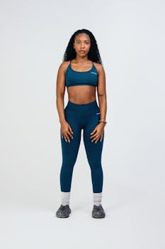 Young woman posing confidently in blue athletic wear against a clean background.