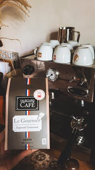 A bag of Faubourg Café Le Gourmet in front of a classic espresso machine.