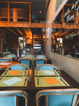 Warm and inviting rustic restaurant interior with wooden loft and dining setup.