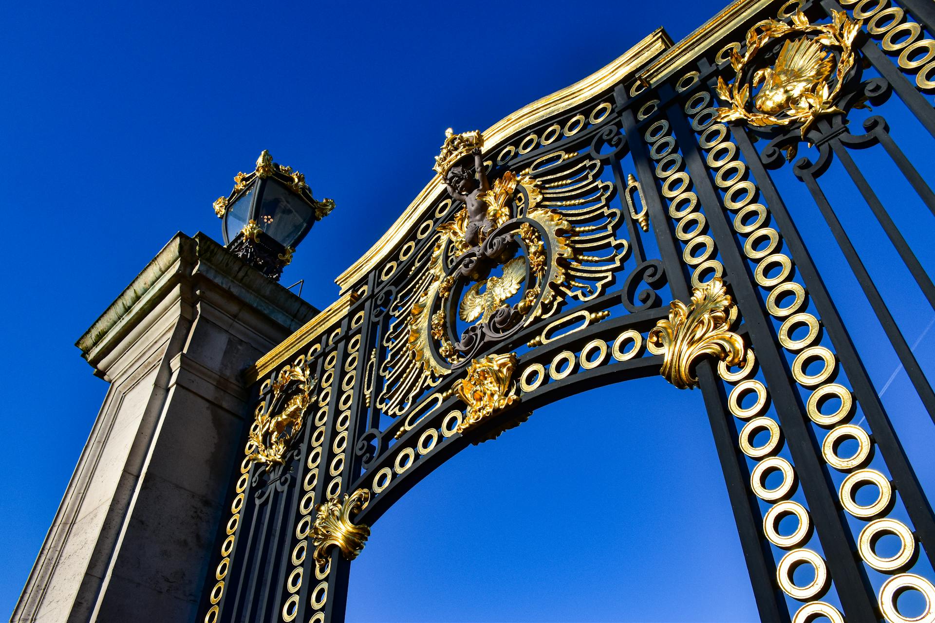 Vue rapprochée des intricées portes d'entrée dorées et noires du palais de Buckingham à Londres, en Angleterre.