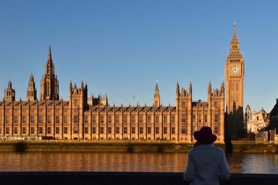 A silhouette of a person enjoying the sunset view of Big Ben and the Houses of Parliament in London, UK.