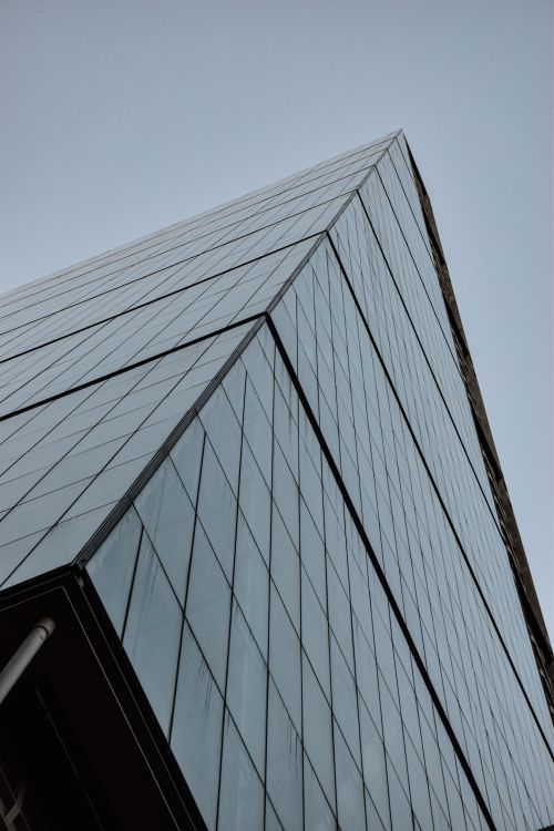 Free Upward view of a modern glass skyscraper in London against a clear sky. Stock Photo