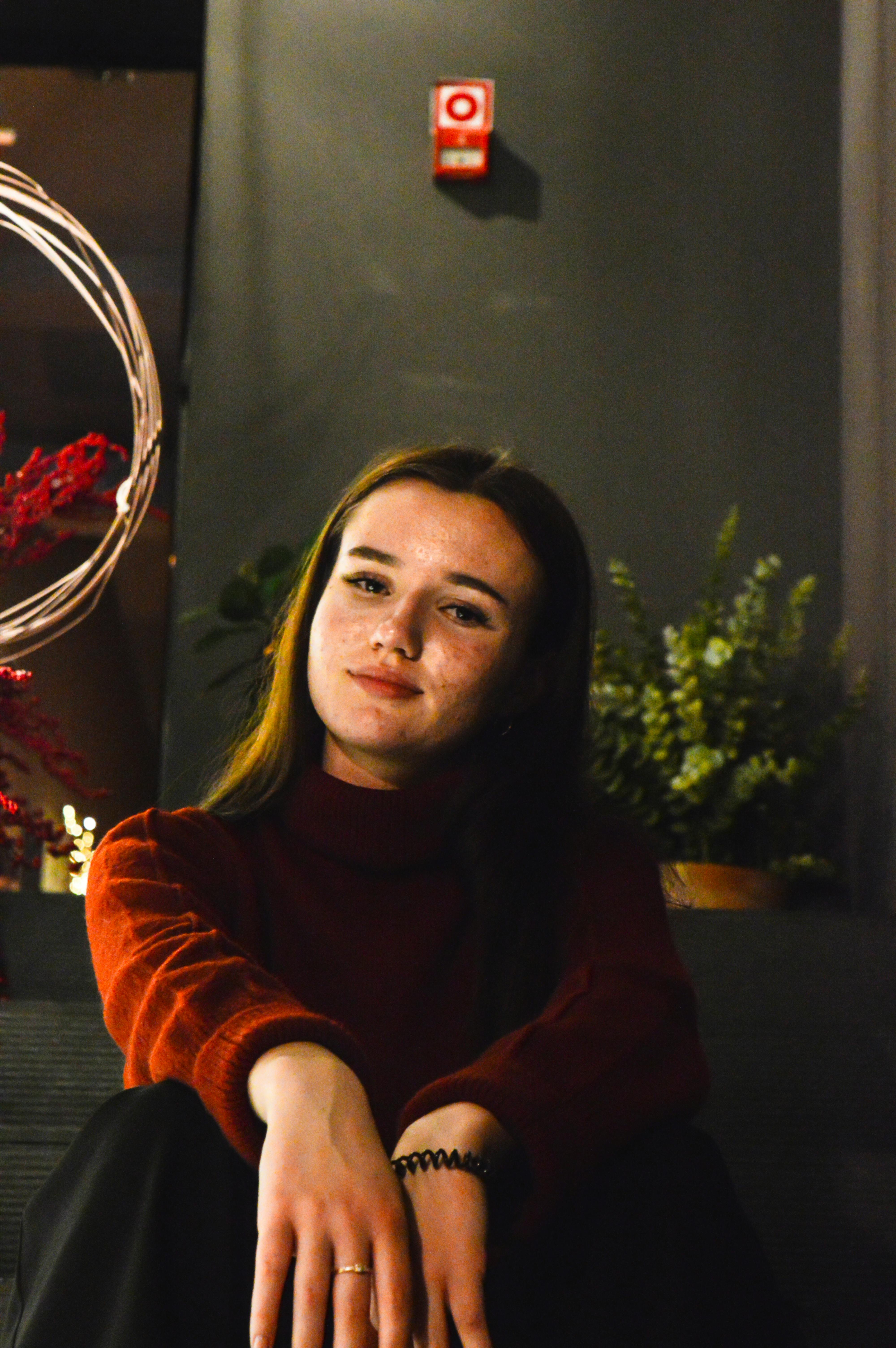 Warm indoor portrait with relaxed expression — comfortable domestic setting soft warm light genuine ease