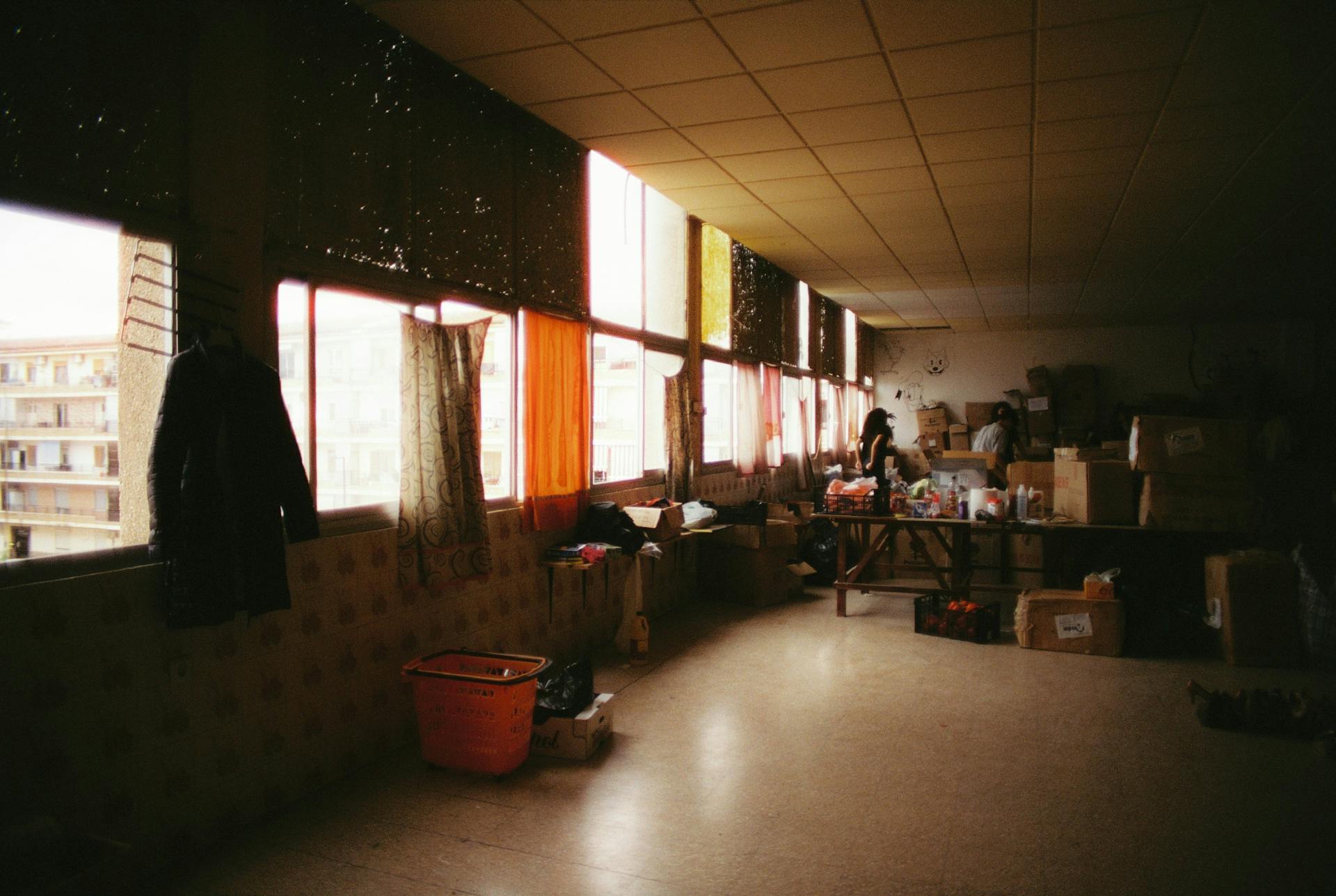 Large indoor storage space with boxes and clothing by a window in Alfafar, Spain.