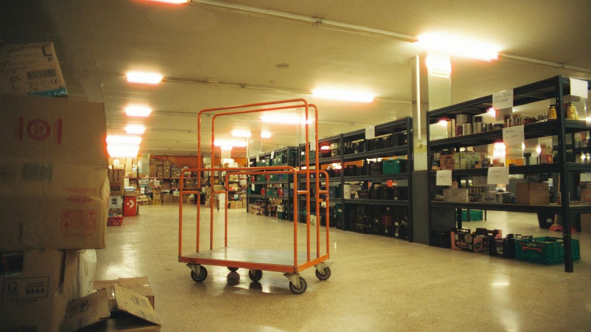 Depósito industrial amplio con estanterías y carro de reposición