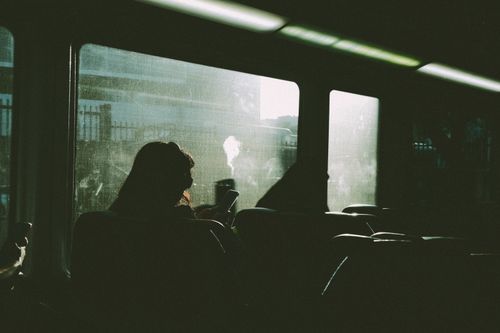 Free Silhouette of a person using a phone on a train journey, sunlight streaming in. Stock Photo